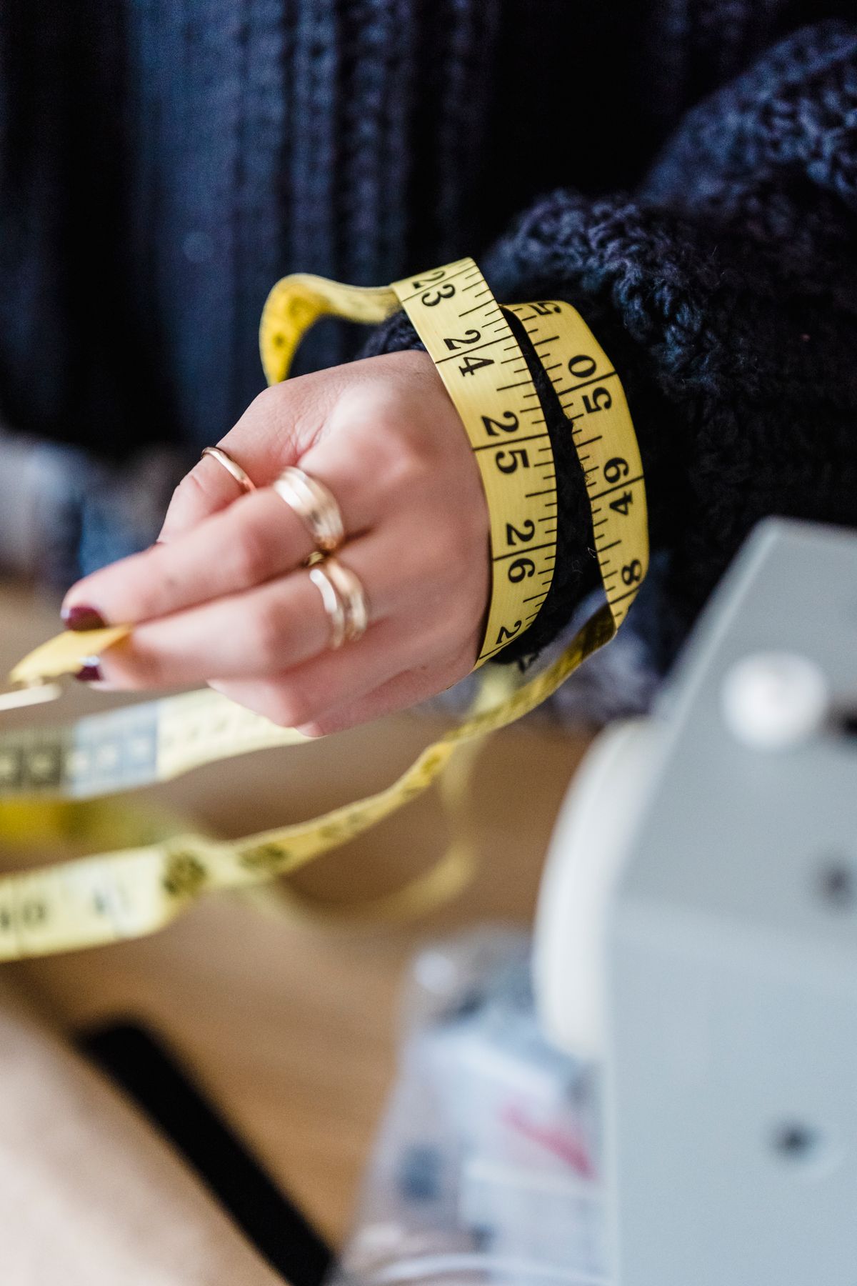 Close-up of a measuring tape in a tailor's hand